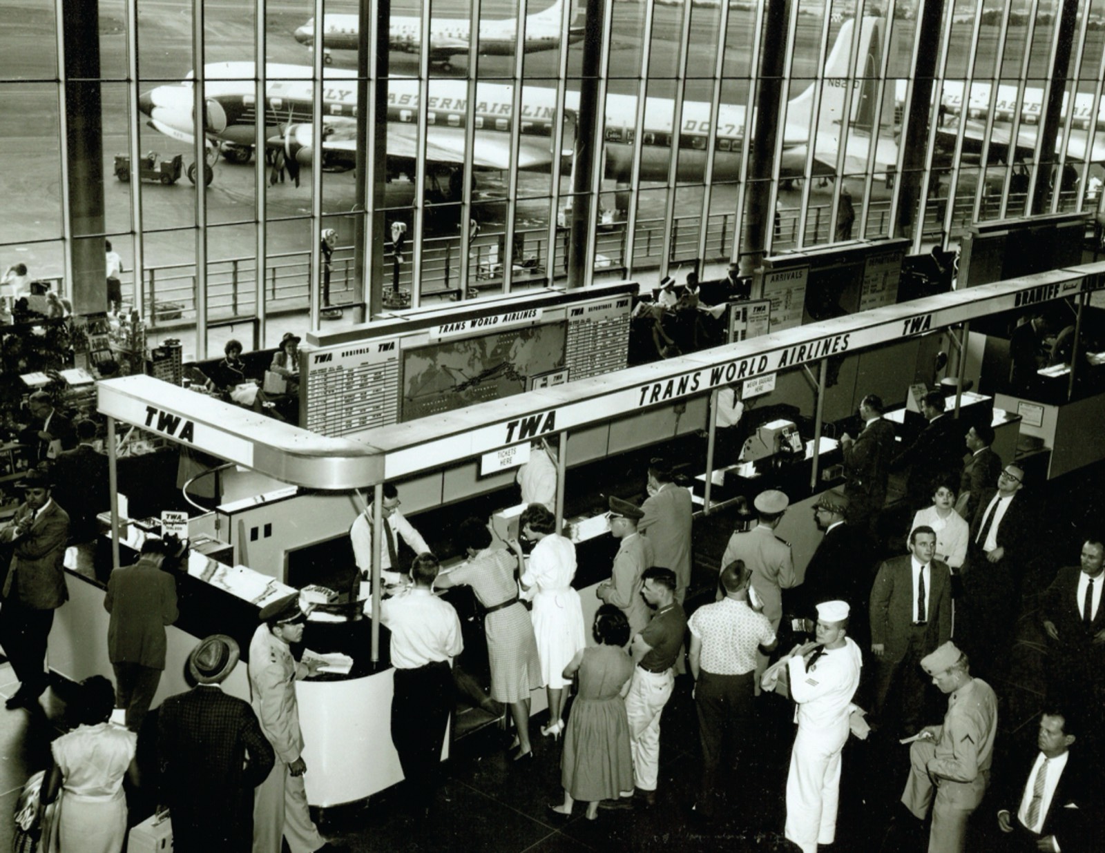 Passengers queueing at an airline ticket counter in the 1960s